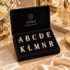 Gold and silver alphabet letter lapel pins in branded gift box