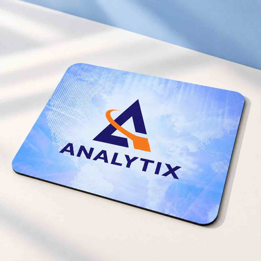 Analytix custom branded blue mouse pad displayed on a clean white workspace with soft blue background
