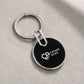 Custom black circular CIPHER ACES metal keychain displayed at an angled view on a light concrete surface