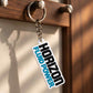 Personalized white Horizon Fluid Power acrylic keychain with black and turquoise lettering on a warm wooden key holder