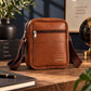 Custom logo leather sling bag with adjustable strap on wooden desk