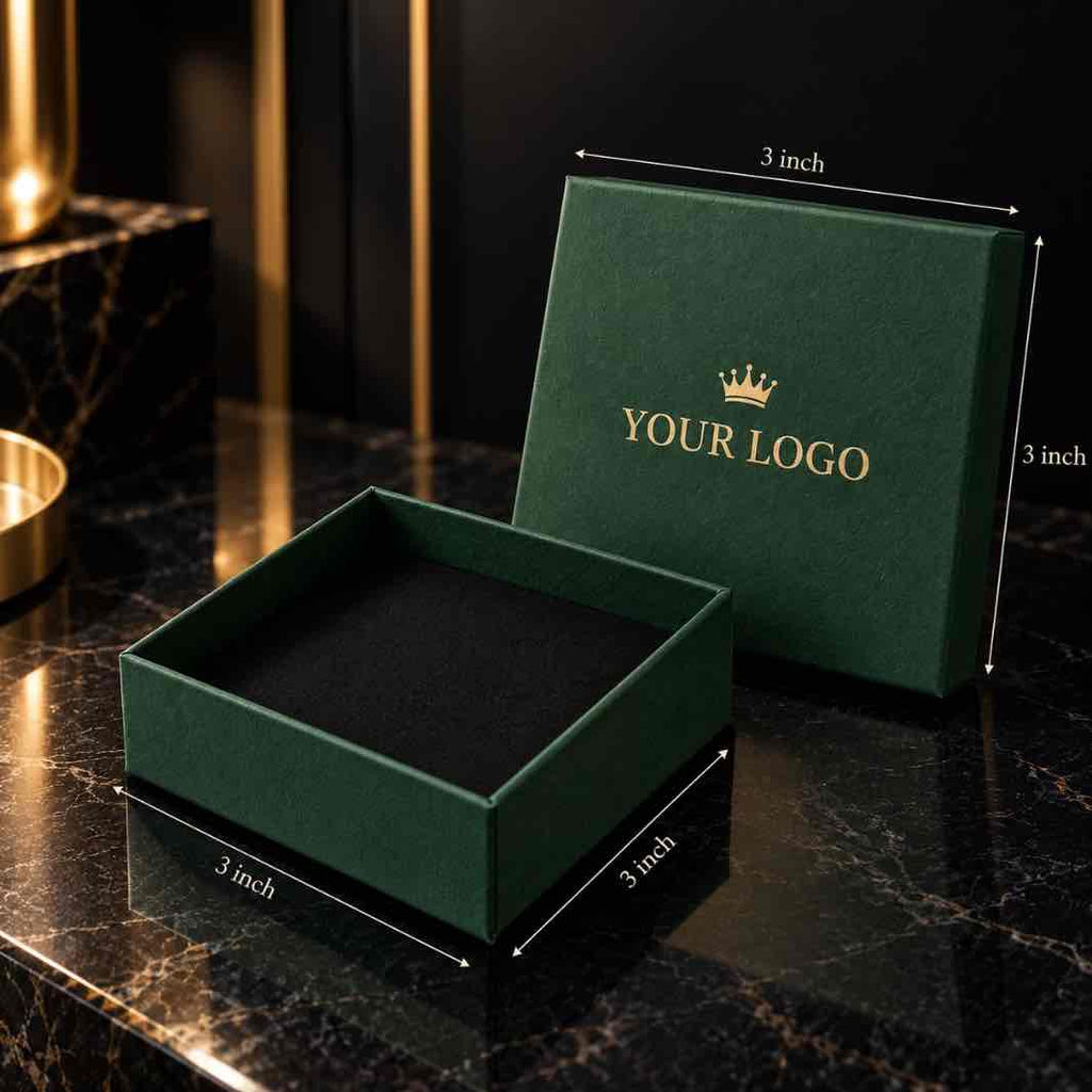 A dark green square gift box shown open with its lid leaning behind it on a black marble surface. White dimension lines and text indicate 3 inch measurements.