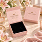 A pink jewelry gift box shown open with a black velvet interior, alongside a closed matching pink box. The boxes have gold placeholder logo text reading 'YOUR LOGO' and 'MADE JUST FOR YOU.