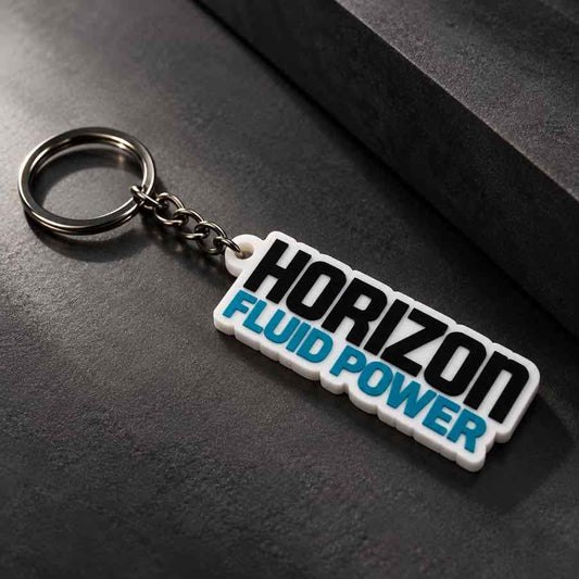 White Horizon Fluid Power personalized keychain with silver metal ring displayed diagonally on a dark textured surface