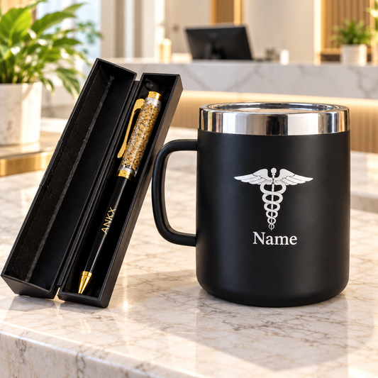 Personalized black medical mug with white medical symbol and “Name” lettering paired with an ANKX black-and-gold pen in an open black gift case on a marble office counter.