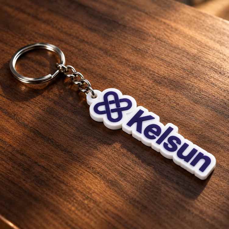 White acrylic Kelsun personalised keychain with purple logo and lettering on a rich walnut wooden surface. 