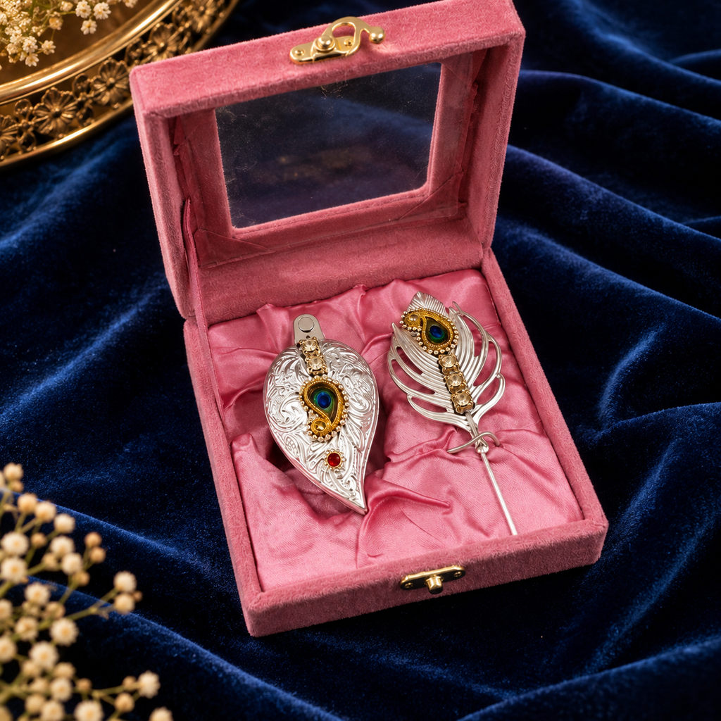 Pink velvet jewelry presentation box with two ornate silver and gold decorative pieces, blue and red gemstone details, displayed on royal blue velvet.