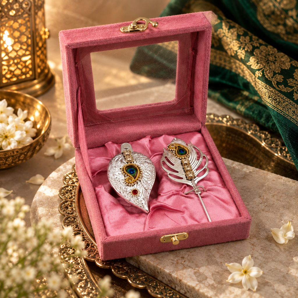 Pink velvet jewelry gift box with two ornate silver and gold decorative pieces, blue and red gemstone accents, styled with elegant festive décor.
