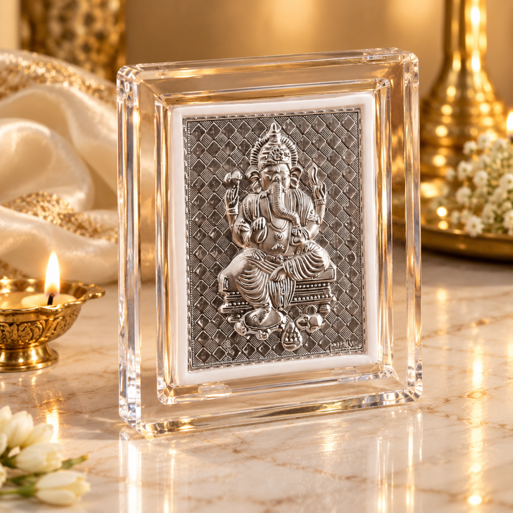 Silver Lord Ganesha artwork in a transparent frame displayed on white marble with elegant golden festive decor