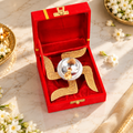 Swastik Diya in a red velvet presentation box displayed on white marble with elegant jasmine flowers and festive Indian décor.