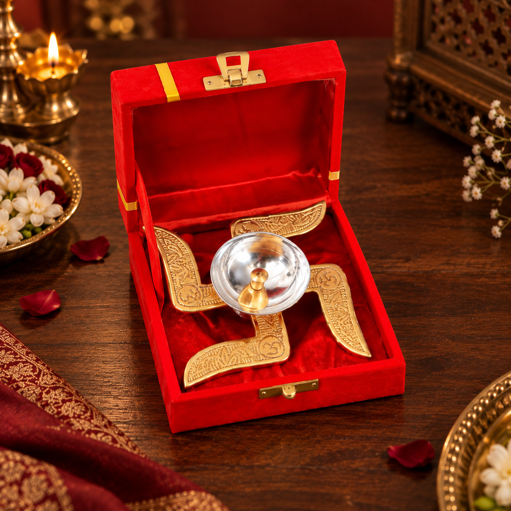 Swastik Diya placed inside a red velvet presentation box on a wooden table, featuring gold Swastik detailing and a silver diya for festive gifting.
