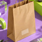 A brown kraft paper shopping bag with twisted paper handles and a blank white label window on the front, styled on purple and lime green geometric platforms.