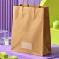 Brown kraft paper carry bag styled with lavender and lime green geometric elements in a modern product photoshoot