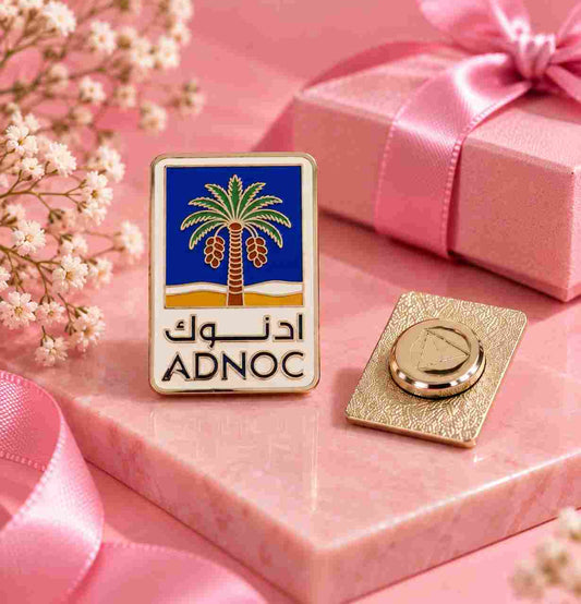 Personalized ADnoc logo lapel pin styled with a pink gift box, soft floral details and a feminine premium gifting theme.