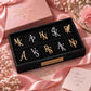 A curated collection of personalized letter brooches, available in gold and silver finishes to suit any style. Each initial pin is carefully arranged in a sleek black box lined with gold-accented labeling. The styling includes delicate dried flowers and a premium gift box, highlighting the brand's "Good Style, Good Stories" ethos. Ideal for adding a custom, monogrammed touch to outfits.