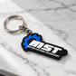 A black and blue MOTION SYSTEMS TECHNOLOGY keychain with a silver metal split ring, resting on a white marble surface.
