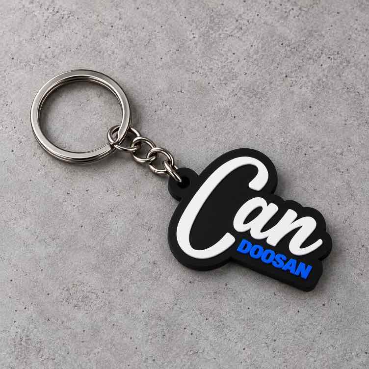 Custom MST Motion Systems Technology keychain with black and blue gear design, white MST lettering, silver chain and metal keyring on a light textured surface.
