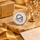 Gold-rimmed CA India round brooch displayed on an elegant golden marble gift setting
