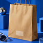 Brown kraft paper carry bag showcased against an electric blue backdrop in a modern Gen-Z product setup
