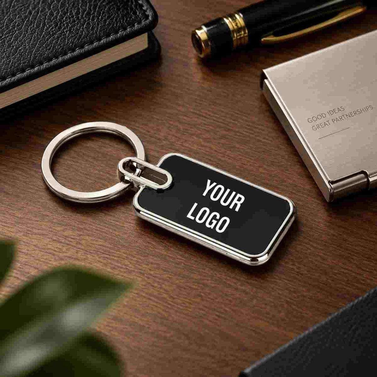 Luxury black metal keychain with custom logo, silver keyring, and polished edges displayed in a stylish executive workspace.