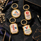 Gold custom logo keychains in four shapes, personalized with your name and logo. Styled on black marble for a bold, luxury promotional gift presentation.